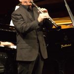 CAMERISTI DELLA SCALA Direttore ERNEST HOETZL CARL STAMITZ CONCERTO IN SI BEM. MAGG. per due clarinetti e orchestra Allegro Andante Moderato Allegro FABRIZIO MELONI, DARKO BRLEK, clarinetti ENNIO MORRICONE NOTTURNO PASSACAGLIA per clarinetto, flauto, oboe, pianoforte e archi Dedicato dall’autore a Massimo Mercelli e Darko Brlek in occasione del 60° della European Festival Association DARKO BRLEK, clarinetto MASSIMO MERCELLI, flauto SERGEJ PROKOF’EV PIERINO E IL LUPO Con la partecipazione di AUGUSTA GORI Disegni di LAURA BELLINI Partner Impaginazione e stampa PINELLI PRINTING srl Imparare ad ascoltare Grande, piccola, da camera, sinfonica… Le dimensioni di un’orchestra variano per adattarsi ai repertori e ai luoghi in cui la musica è eseguita. Ma c’è qualcosa di stabile che colpisce anche l’ascoltatore più distratto: il gruppo degli archi è in assoluto il più nutrito. Tale asimmetria cominciò a delinearsi intorno alla metà del Settecento e a dargli impulso fu l’orchestra più ammirata del secolo, quella di Mannheim. Essa era molto numerosa, essendo costituita da una cinquantina di elementi (alla corte viennese, ad esempio, ve n’e-rano appena trenta), e includeva, cosa insolita, ben tre clarinetti, strumenti di recentissima invenzione. Que-sto ensemble eccezionale ebbe un ruolo di primo piano nel rinnovamento del gusto e delle forme musicali, accompagnando la transizione dal Barocco al Classicismo. Presso tale orchestra si formò come violinista e compositore Carl Stamitz. Nel 1770 il musicista decise di in-traprendere la carriera del libero professionista, affrancandosi dalla corte e raggiungendo Parigi. Qui incon-trò il virtuoso del clarinetto Johann Joseph Beer, suo collega a Mannheim, con il quale iniziò una collabora-zione feconda. Fra le prime composizioni che Stamitz dedicò all’amico c’è il Concerto per due clarinetti in Si bemolle maggiore, nato per stupire il pubblico parigino dei Concerts Spirituels con una proposta inedita. Purtroppo, l’idea del giovane artista era così originale e i clarinettisti dell’epoca erano così rari che Stamitz stesso dovette accompagnare Beer, interpretando al violino la parte del secondo clarinetto. Sin nel primo movimento, l’autore fa sfoggio di una risorsa imparata a Mannheim: l’uso del crescendo; i cambiamenti di-namici erano infatti una grande specialità di quell’orchestra tedesca ammirata e imitata in tutta Europa. Il successivo Andante moderato si segnala per la sua elegante tenerezza, mentre il finale, brevissimo, è un mi-nuetto molto vivace. La parte dei solisti è sempre brillante, ma elude l’ostentazione virtuosistica. La sezione degli archi costituisce la colonna portante dell’orchestra anche nelle opere di molti compositori moderni: un chiaro esempio è il Notturno e passacaglia per Cervara di Ennio Morricone, in cui questi stru-menti creano un delicato tappeto sonoro per far spiccare le voci di clarinetto, oboe e flauto. I tre legni, con i loro gentili arabeschi sonori, evocano l’atmosfera serena e agreste di Cervara, un borgo laziale in cui il compositore adorava trascorrere le vacanze estive insieme alla famiglia. Se il pezzo, scritto nel 1996, faces-se parte di una delle sue celebri colonne sonore, sarebbe senz’altro associato a un paesaggio naturale not-turno ma inquadrato da un interno domestico, poiché è tutto sussurrato, intimo, sempre fra il piano e il pia-nissimo. Per dare forma al suo omaggio musicale, Morricone prese spunto dalla passacaglia; com’è tipico di quella danza d’origine rinascimentale, la composizione è percorsa da un motivo che si ripete con ostina-zione: in questo caso, una formula essenziale di sole due note. I più piccoli possono apprezzare l’importanza degli archi nell’equilibrio sonoro di un’orchestra attraverso un classico intramontabile del repertorio infantile, Pierino e il lupo di Sergej Prokof’ev. L’obiettivo di questa favola musicale, commissionat a nel 1936 dal Teatro per Bambini di Mosca, è insegnare a distinguere gli strumenti e le loro caratteristiche timbriche. Ogni personaggio, infatti, è associato a uno strumento e a un te-ma musicale: Pierino, svolgendo il ruolo principale, è rappresentato da una melodia baldanzosa affidata agli archi; l’anatra ha la voce nasale dell’oboe; gli scoppi dei fucili sono resi dai colpi dei timpani; il nonno, un uomo anziano e lamentoso, è impersonato dal fagotto, ecc. Così come nella storia i personaggi interagisco-no, nella partitura i temi si combinano per creare una musica divertente e facile da decifrare. Prokof’ev, che amava raccontare storie ai suoi bambini, scrisse egli stesso il testo e poi compose la musica di getto: in appena una settimana la versione preliminare per pianoforte era stata ultimata e dopo altri sette giorni anche l’orchestrazione fu approntata. La sua favola bonaria non ebbe un grande successo in Russia, ma conquistò Walt Disney quando l’autore gliela presentò a Los Angeles nel 1938 diventando immediata-mente un cartone animato. Da allora Pierino e il lupo non ha mai smesso di incantare gli ascoltatori di ogni latitudine, non solo per la sua musica orecchiabile, ma anche perché racconta un’esperienza universale: il momento in cui decidiamo di valicare un limite rassicurante per affrontare le nostre paure. Liana Püschel Cameristi della Scala L’orchestra da camera dei Cameristi della Scala è formata da musicisti dell’Orchestra del Teatro alla Scala e ha iniziato la sua attività nel 1982. I Cameristi hanno eseguito concerti nei teatri e nelle sale da concerto più pre-stigiose del mondo. Nel corso della stagione 2018-2019 hanno fatto il loro debutto alla Victoria Hall di Ginevra e tenuto concerti alla Maison de la Culture di Grenoble, all’Istanbul Music Festival, al Festival di Lubiana, al Festival Enescu e all’Autumn Tbilisi Music Festival. La scorsa stagione si è aperta con uno straordinario evento al World Economic Forum di Davos, i Cameristi della Scala e Roberto Bolle sono stati i protagonisti della serata inaugurale del WEF con la prima mondiale dello spettacolo The Seasons. Altri importanti appuntamenti sono stati la prima tournée in India, un concerto al Teatro alla Scala dedicato al genio di Leonard Bernstein, con in programma una nuova commissione affidata a Giovanni Sollima, il concerto inaugurale del festival che si tiene nella splendida cornice dell’arena romana di El Jem in Tunisia e il concerto conclusivo delle Variations Musicales de Tannay in Svizzera. Negli ultimi anni hanno suonato per due stagioni alla Carnegie Hall e nella Sede dell’ONU di New York, al MIT di Boston, a Washington, Miami e Providence, in tre occasioni a Mosca nella sala Čaikovskij, a Madrid all’Auditorio Nacional, a Buenos Aires al Teatro Coliseo, a Parigi nella sede dell’Unesco e nella Salle Gaveau, a Istanbul nella magica cornice di Hagia Irene e Is Sanat, a Varsavia nel Teatro dell’Opera, a Zurigo nella Tonhalle, a Toronto nel Sony Center e, in tournee, in Spagna, Germania, Francia, Svizzera, Svezia, Norvegia, Danimarca, Polonia, Lettonia, Lituania, Serbia, Turchia. Nel 2010 i Cameristi hanno effettuato una tournee di quattro concerti in Israele, suonando tra l’altro nell’auditorium Mann di Tel Aviv, e hanno eseguito quattro concerti a Shanghai, con grande successo e affluenza di pubblico, in rappresentanza della citta di Milano all’Expo 2010. Dal 2007 al 2009 sono stati i protagonisti, in piazza del Duomo a Milano, del Grande concerto d’estate, suonando sul sagrato alto del Duomo davanti a più di diecimila spettatori. Nel 2007 e nel 2008 hanno rappresentato, su incarico del Comune di Milano, l’eccellenza e la cultura milanese con concerti nelle principali capitali europee per l’assegnazione di EXPO 2015. Nel 2011, nell’ambito delle celebrazioni del 150° dell’Unità d’Italia e in collaborazione con l’Associazione Musica del Risorgimento, hanno svolto un impor-tante lavoro di ricerca sul repertorio inedito ottocentesco, e hanno realizzato un CD, uscito nelle edicole in 20.000 copie, dedicato a musiche italiane del periodo risorgimentale. Hanno inoltre curato la pubblicazione di tre volumi di musiche inedite risorgimentali. Nel 2012 i Cameristi hanno ricevuto dalla Provincia di Milano il Premio Isimbardi, destinato alle istituzioni che, con la loro importante attività internazionale, hanno contribuito al prestigio della città di Milano nel mondo. Nell’autunno 2017 Wilson Hermanto, in occasione di un concerto tenuto a Zurigo, ha assunto il ruolo di Direttore Ospite Principale. Violini primi: Agnese Ferraro, Suela Piciri, Gianluca Scandola, Leida Sheshaj, Lucia Zanoni Violini secondi: Duccio Beluffi, Roberto Nigro, Estela Sheshi, Olga Zakharova Viole: Francesco Lattuada, Joel Imperial, Matteo Amadasi Violoncelli: Jakob Ludwig, Simone Groppo, Gianluca Muzzolon Contrabbasso: Giuseppe Ettorre Flauto: Marco Zoni Oboe: Fabien Thouand Fagotto: Nicola Meneghetti Tromba: Marco Toro Corni: Roberto Miele, Claudio Martini, Matteo Arcieri Trombone: Simone Periccioli Timpani: Andrea Bindi Percussioni: Gianni Arfacchia Pianoforte: Paolo Spadaro Ernest Hoetzl. Nato a Bruck an der Mur, in Stiria (Austria), è laureato in filologia classica, didattica della musica e in musicologia. Ha studiato pianoforte con Chung Lee e Rudolf Schwenzer, direzione d’orchestra a Graz con Milan Horvat e poi all’Università del Texas a Austin. È professore straordinario di storia della musica alla Kunstuniversität di Graz. Poliglotta e ambasciatore della cultura musicale austriaca, è Direttore artistico del Musikverein Jeunesse Kärnten, la Gioventù musicale della Carinzia, e dirige regolarmente più di ottanta orchestre in tutto il mondo, tra cui la Filarmonica di Zagabria, l’Orchestra Sinfonica della Radio di Praga, i Berliner Symphoniker, l’Orchestra Sinfonica della Radio ungherese (MÁV), l’Orchestra ajkovskij di Mosca, la Tokyo New City Orchestra, in sedi prestigiose qua-li il Musikverein di Vienna, la Philharmonie di Berlino, il Rudolfinum di Praga, la Carnegie Hall di New York e il Festival di Bregenz, il Teatro Amazonas di Manaus o al National Center for the Performing Arts di Bombay. È l’unico direttore che ha lavorato in entrambe le Coree. Ha pubblicato il volume Heute Musikgeschichte? Versuch einer Perspektive (Vienna 1995). Per i suoi meriti nel campo della musica e della sua diffusione, ha ottenuto importanti distinzioni e riconoscimenti, quali la Croce d’onore per le Scienze e per le Arti della Repubblica Austriaca, la Medaglia al merito della Carinzia e la Medaglia d’oro della Stiria. Fabrizio Meloni. Primo clarinetto solista dell’Orchestra del Teatro e della Filarmonica della Scala dal 1984, ha compiuto gli studi musicali al Conservatorio “G. Verdi” di Milano diplomandosi con il massimo dei voti, la lode e la menzione d’onore. È vincitore di concorsi nazionali ed internazionali: ARD Monaco, Primavera di Praga nel 1986. Ha collaborato con solisti di fama internazionale quali Bruno Canino, Alexander Lonquich, Michele Campanella, Heinrich Schiff, Friederich Gulda, Edita Gruberova, il Quartetto Hagen, Myung-Wh un Chung, Phillip Moll, Riccardo Muti e Daniel Barenboim (quest’ultimo nella veste straordinaria di pianista). Ha tenuto tournée negli Stati Uniti e in Israele con il Quintetto di Fiati Italiano, eseguendo brani dedicati a questa formazione da Berio e Sciarrino (dal 1989 al 1994 ha collaborato intensamente con Luciano Berio). Con il Nuovo Quintetto Italiano, nato nel 2003, ha all’attivo tournée in Sud America e nel Sud Est Asiatico. La sua tournée di concerti in Giappone con P. Moll e I Solisti della Scala è stata accolta da entusiastici consensi di pubblico e critica, ed il programma di musiche italiane è stato raccolto nel CD I Fiati all’opera. Ha all’attivo numerose incisioni discografiche di brani per orchestra, quintetti ed en-semble jazz. La rivista Amadeus gli ha dedicato diverse pubblicazioni. stato invitato a tenere masterclass al Conservatorio Superiore di Musica di Parigi, a quello della Svizzera Italiana, alla Manhattan School of Music di NewYork, alla Northeastern Illinois University di Chicago, alla Music Academy di Los Angeles e alle Università di Tokyo e Osaka. Docente inoltre nei corsi di alto perfezionamento presso Accademia Teatro alla Scala, Conservatorio “G. Verdi” di Milano, Accademia Milano Music Master, Associazione Lirico Musicale “Giovani all’Opera” di Roma, Conservatorio “J. Tomadini” di Udine, Conservatorio Superiore di Musica di Saragozza, Istituto Musicale “A. Masini” di Cesena, Isti-tuto Superiore “A. Peri” di Reggio Emilia, Conservatorio di Musica “P. Čajkovskij” (CZ), Accademia Albero della Musi-ca di Milano. È inoltre autore del libro Il clarinetto. È solista principale dell’Orchestra Sinfonica Abruzzese ch’egli ha anche diretto, nel maggio 2012, nella Messa in do min K. 417 di Mozart. Nel 2015 ha tenuto una lunga tournée in Giap-pone con Yoshikawa e la loro esibizione presso la Suntory Hall di Tokyo è stata trasmessa sul canale giapponese NHK. Vanta numerose incisioni tra cui un CD interamente dedicato al repertorio francese per clarinetto e pianoforte. Di recentissima pubblicazione Wind Concertos di Alexandre Tasman con la Malta Philharmonic Orchestra e un cd con musiche di Stravinskij ed Eötvös con i Solisti del Teatro alla Scala. Darko Brlek. Diplomato con il massimo dei voti all’Accademia di Ljubljana dove ha studiato con con Miha Gunzk, si è perfezionato in seguito con Alois Brandhofer e con Bela Kovacs. Vincitore di numerosi concorsi, è stato Primo clarinetto dell’Orchestra dell’Opera di Ljubljana e poi direttore dell’Opera e Balletto Nazionale Sloveno. Oggi è direttore artistico e General Manager del Festival di Ljubljana. Svolge un’intensa attività concertistica come solista, con il suo ensemble Trio Luwigana fondato nel 1993 e in svariate formazioni cameristiche. Si è esibito in Italia, Austria, Germania, Francia, Spagna, Portogallo, Belgio, Lituania, Bulgaria, Jugoslavia, Macedonia, Turchia, Russia, Stati Uniti e Messico. Ha lavorato con numerosi artisti di fama internazionale tra cui Anton Nanut, Piérre Amoyal, Uto Ughi, Lovro Pogorelić. In veste di solista si è esibito con orchestre quali Orchestra Sinfonica della Radio Slovena, Deutsches Kammerorchester, Mannheim Kammerorchester, Orchestra da Camera di Mosca, Orche-stra Sinfonica di Stato Messicana, Orchestra Sinfonica di Stato Lituana. Viene spesso invitato a tenere masterclass in Slovenia e all’estero. Ha al suo attivo numerose incisioni discografiche e registrazioni per la Radio e Televisione Slovena, per le radio nazionali di Francia e Spagna, per HSR, RAI, ORF, SRT e per la televisione messicana. Massimo Mercelli. Autodidatta e poi allievo dei celebri flautisti Maxence Larrieu ed André Jaunet, a diciannove an-ni diventa Primo flauto al Teatro La Fenice di Venezia, vince il Premio Francesco Cilea, il Concorso Internazionale Giornate Musicali e due edizioni del Concorso Internazionale di Stresa. Suona regolarmente nelle maggiori sedi con-certistiche: Carnegie Hall di New York, Herculessaal e Gasteig di Monaco, NCPA di Pechino, Teatro Colon di Buenos Aires, Concertgebouw di Amsterdam, Teatro alla Scala, Auditorium RAI di Torino, Victoria Hall di Ginevra, San Martin in the Fields e Wigmore Hall di Londra, Parco della Musica di Roma, Filarmonica di San Pietroburgo, Filar-monica di Varsavia, Čajkovskij Hall di Mosca, e nei Festival di Ljubljana, Berlino, Santander, Vilnius, San Pietrobur-go,Rheingau, Jerusalem, Warsaw. Collabora con artisti quali Yuri Bashmet, Valery Gergiev, Krzysztof Penderecki, Philip Glass, Michael Nyman, Massimo Quarta, Ennio Morricone, Luis Bacalov, Peter-Lukas Graf, Maxence Larrieu, Aurèle Nicolet, Anna Caterina Antonacci, Ramin Bahrami, Albrecht Mayer, Gabor Boldowsky, Jiri Belolhavec, Catherine Spaak, e con orchestre come i Moscow Soloists, i Wiener Symphoniker, la Prague Philarmonia, la Filarmo-nica di San Pietroburgo, i Virtuosi Italiani, i Salzburg Soloists, la Moscow Chamber Orchestra, la Franz Liszt Cham-ber Orchestra, I Musici. Ha eseguito in prima esecuzione Façades di Philip Glass col compositore al pianoforte, ha suonato alla Grande Sala del Mozarteum di Salisburgo e a Bratislava con John Malkovich come voce recitante e al Festival per gli 85 anni di Krysztof Penderecki alla Filarmonica di Varsavia. Nel 2020 sono previste esibizioni in qua-lità di solista con I Solisti Veneti e la Royal Philharmonic Orchestra. Vanta inoltre importanti dediche e collaborazioni con i maggiori compositori; hanno scritto per lui o ha eseguito le prime assolute di personalità come Penderecki, Gubaidulina, Glass, Nyman, Bacalov, Galliano, Morricone, Sollima. Augusta Gori. Diplomatasi attrice alla Civica Scuola d’Arte Drammatica Piccolo Teatro di Milano nel giugno 1980, ha lavorato con registi quali Carlo Cecchi, Lamberto Puggelli, Eduardo De Filippo, Gabriele Salvatores, Luca Ronconi, Sandro Sequi, Vito Molinari , Marina Spreafi co, Marina Bianchi, Ferdinando Bruni, Tadeusz Bradecki, Krystoff Zanussi, Brigitte Jaques, Giulio Cesare Perrone, Walter Manfré, Maria Elena Mexia, Marco Zannoni. Per RAI 1 ha condotto per sette anni la trasmissione televisiva L’Albero Azzurro, ha inoltre collaborato con il Teatro alla Scala, il Teatro di San Carlo di Napoli, il Maggio Musicale Fiorentino,l’Accademia del Fortepiano in progetti da lei creati per avvicinare i bambini alla musica colta. Autrice di testi teatrali per l’infanzia, ha creato dei corsi per l’apprendimento della lingua inglese attraverso il teatro, destinati ai bambinidella scuola primaria ed infiniti corsi di teatro per bambini. Dal 2004 al 2018 ha tenuto laboratori di teatro applicato alla didattica per l’Università Bicocca/Scienza della Formazione. Ha inoltre inciso due CD, Il disco di Augusta e Canta e gioca con me. Laura Bellini. Nata a Genova nel 1978, dopo gli studi artistici e l’esperienza di due anni nel campo del restauro di dipinti antichi e di dorature, lavora presso l’International School della sua città nelle classi del Pre-Kindergarten. L’osservazione quotidiana e diretta dei bambini, ha indirizzato la sua passione di sempre per il disegno e la pittura verso il mondo dei libri illustrati.